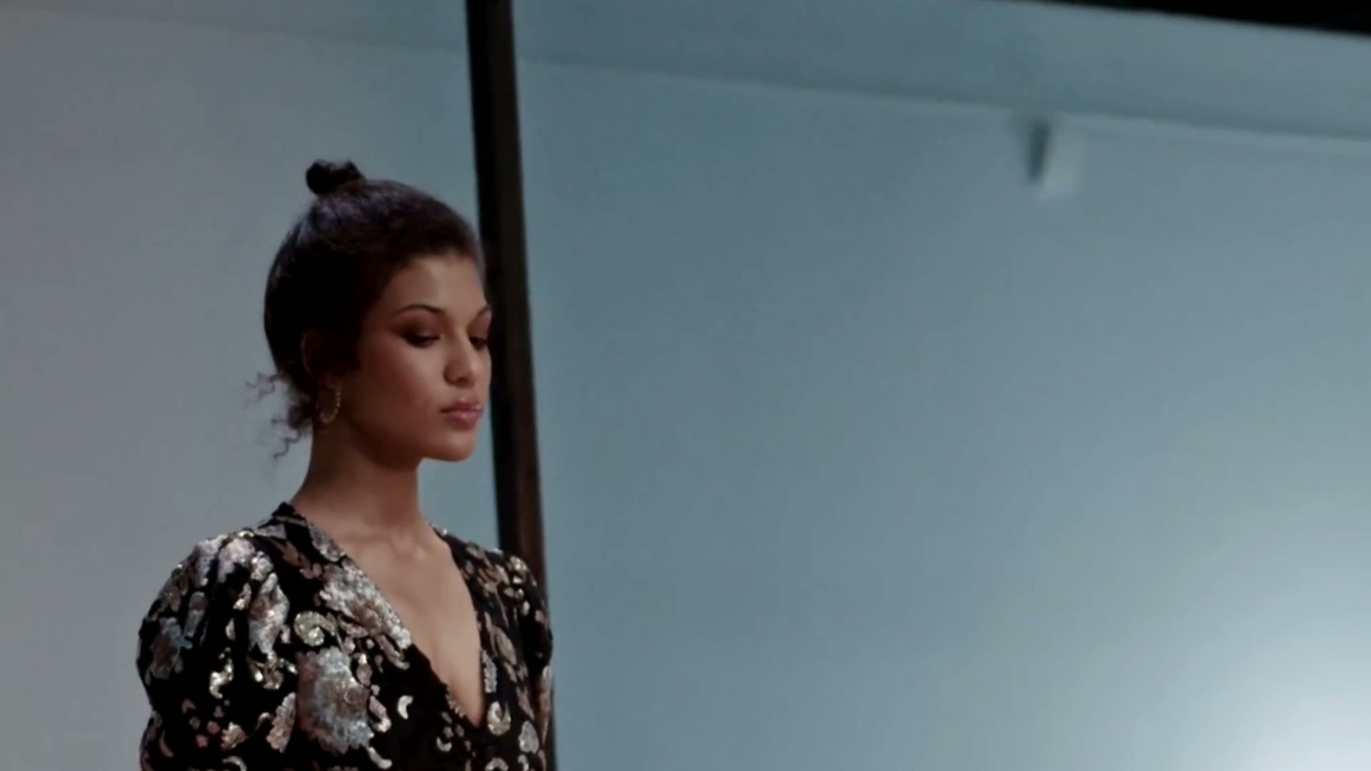 Fashion model in an ornate black and silver look on a minimalist runway